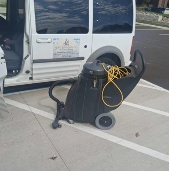 Commercial vacuum and equipment beside the E and H service van